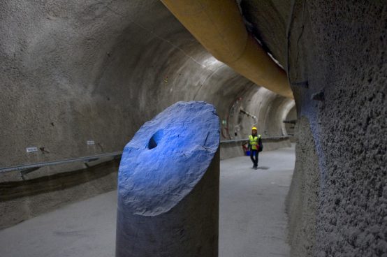 The image shows a Mont Terri collaborator in a gallery of the Mont Terri underground rock laboratory. In the foreground, there sits a 560 mm large diameter core of grey Opalinus Clay. 
